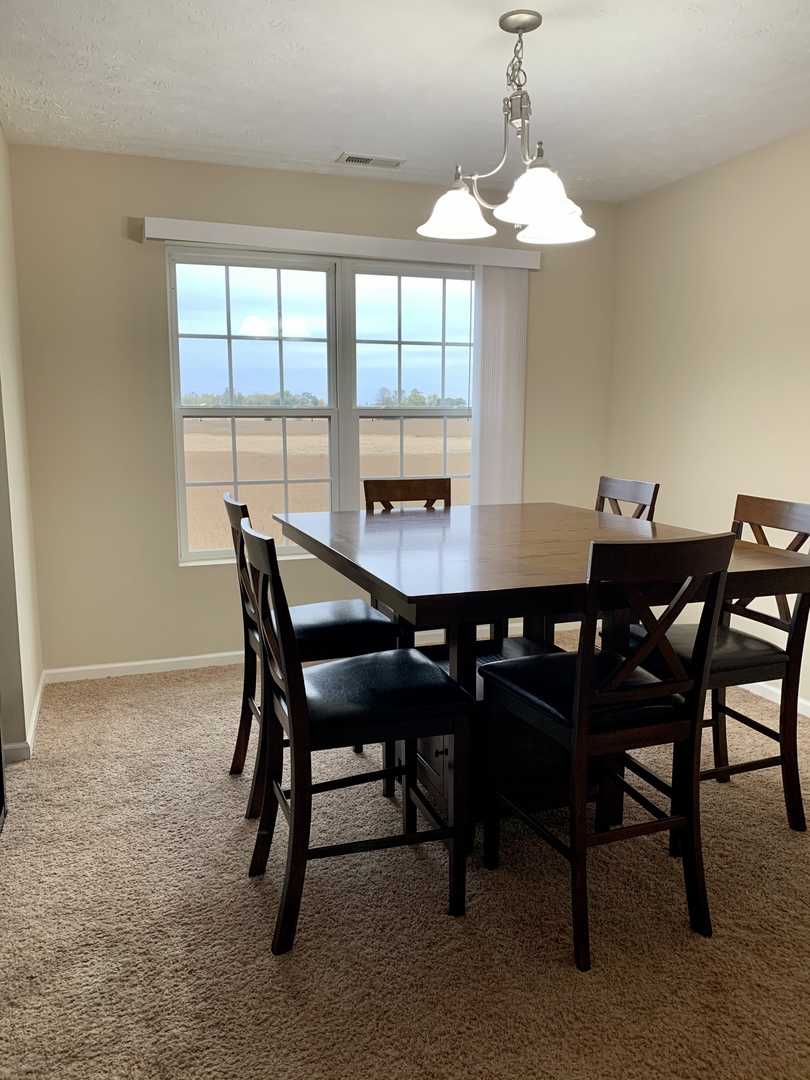 641 Stonegate Drive, Unit 641 Sycamore, IL 60178 - Photo 4 of 13 a dining room with furniture a chandelier and a rug