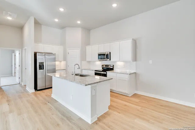 a kitchen with white cabinets and stainless steel appliances
