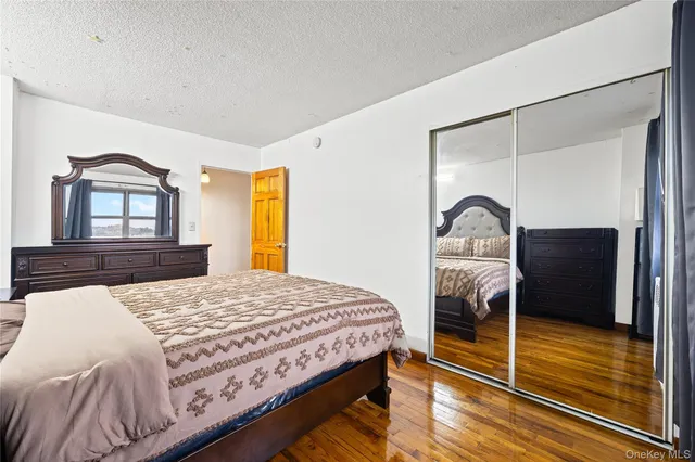 a bedroom with a bed and a dresser with mirror