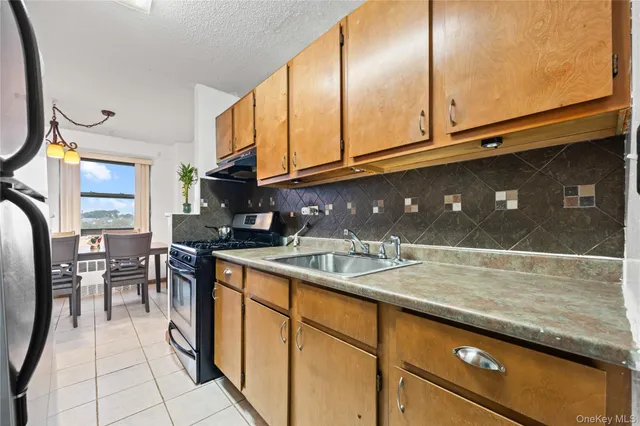 a kitchen with stainless steel appliances granite countertop a sink a stove and cabinets