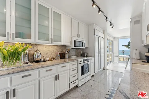 a kitchen with a table chairs stove and wooden floor