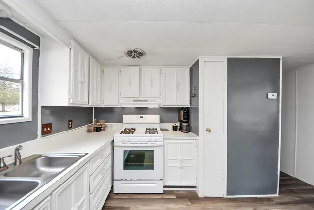 a view of a kitchen with a sink cabinets and wooden floor