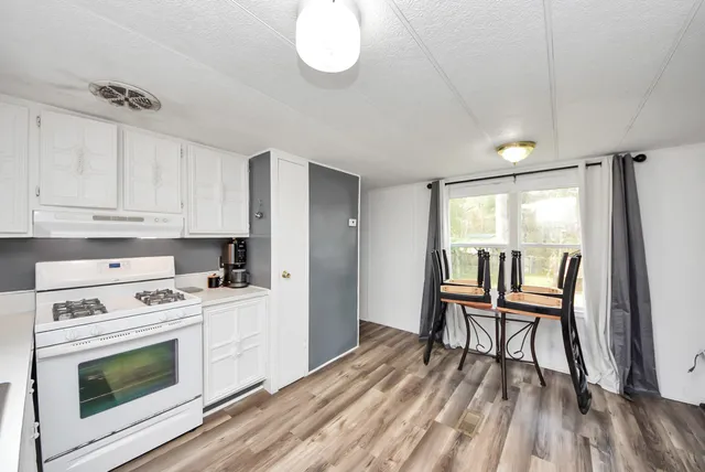 a kitchen with a wooden floor and white appliances