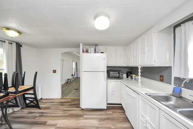 a kitchen with a sink a refrigerator and cabinets