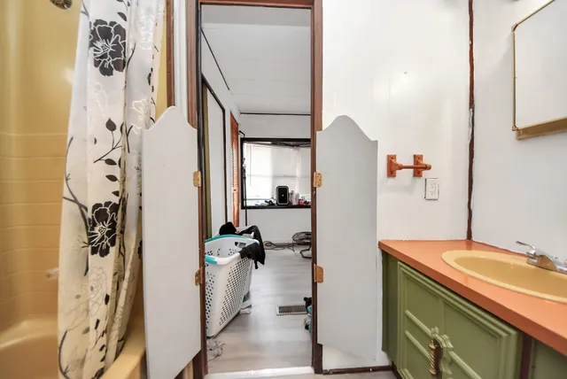 a bathroom with a sink and mirror with shower