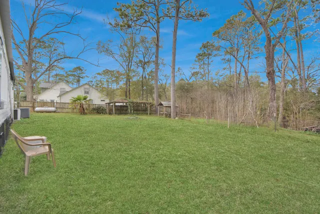 a white house that has a big yard and large trees