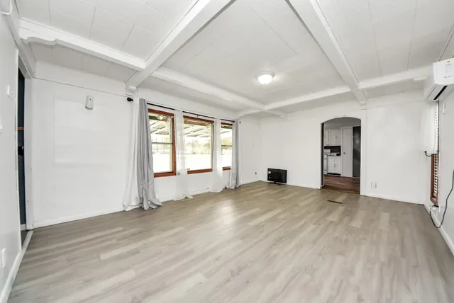 wooden floor in an empty room with a window