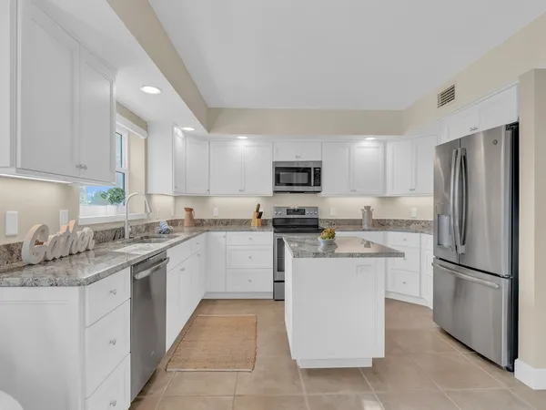 a kitchen with a sink stove refrigerator and microwave