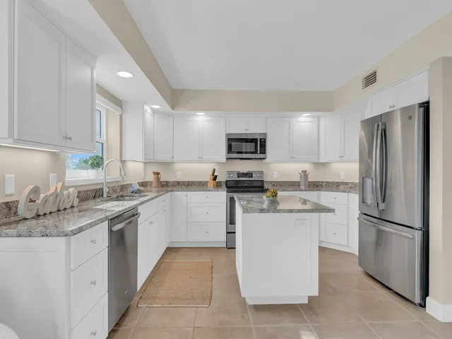 a kitchen with a sink stove refrigerator and microwave