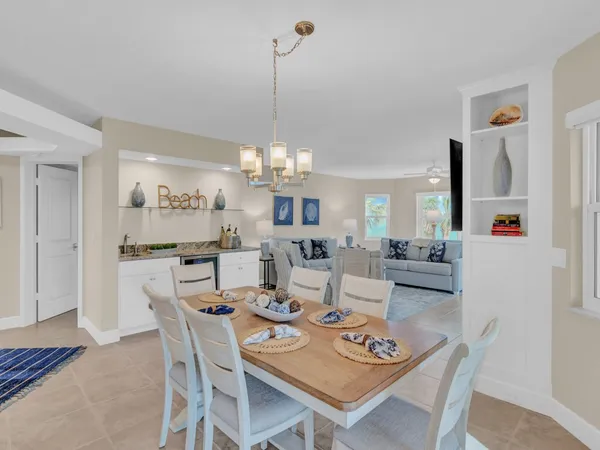 a view of a dining room and livingroom with furniture wooden floor and a chandelier