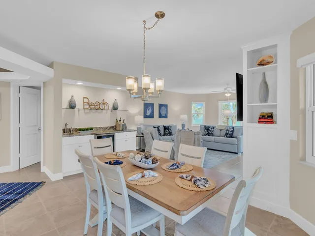 a view of a dining room and livingroom with furniture wooden floor and a chandelier