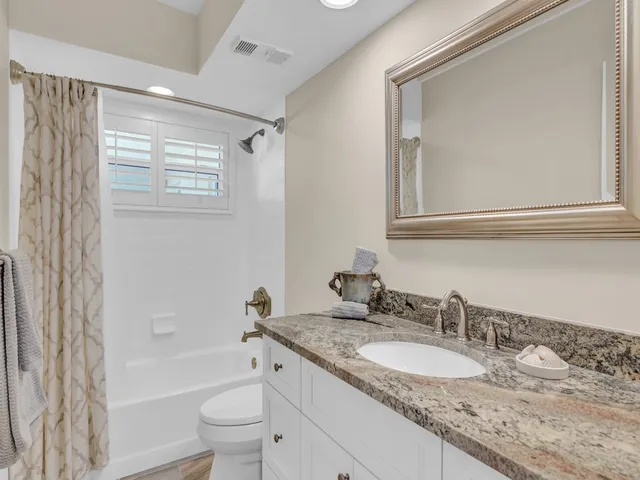 a bathroom with a granite countertop sink toilet and shower