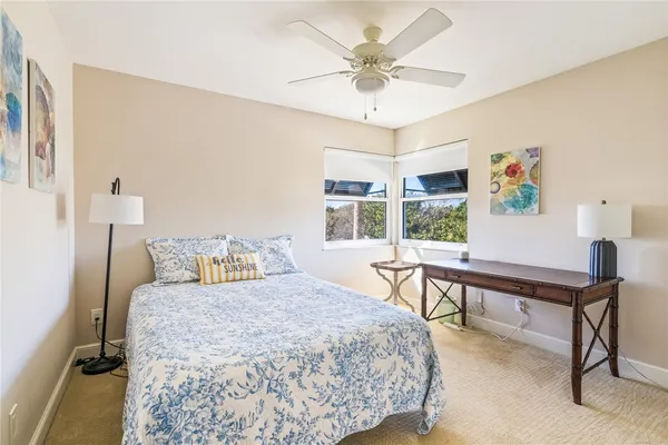 a bedroom with a bed desk and a window
