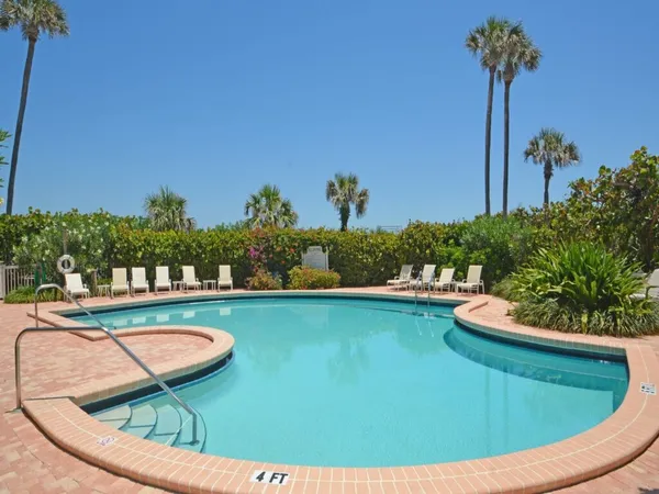 a view of a swimming pool with a yard and plants