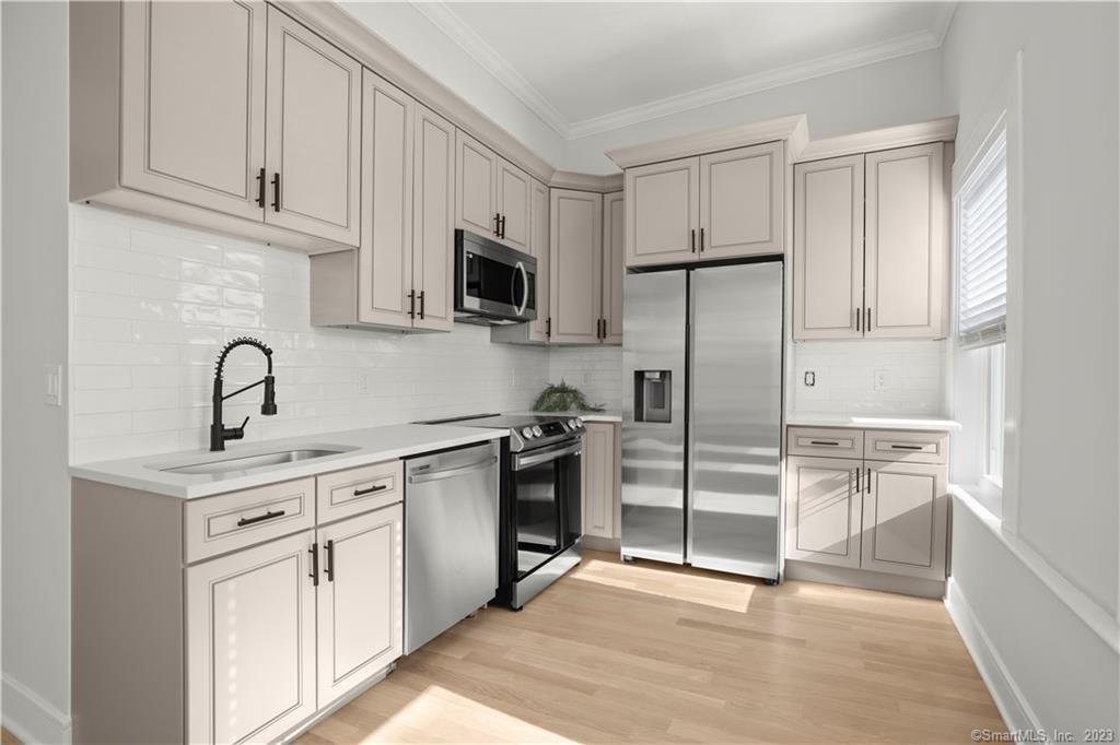 a kitchen with white cabinets and stainless steel appliances