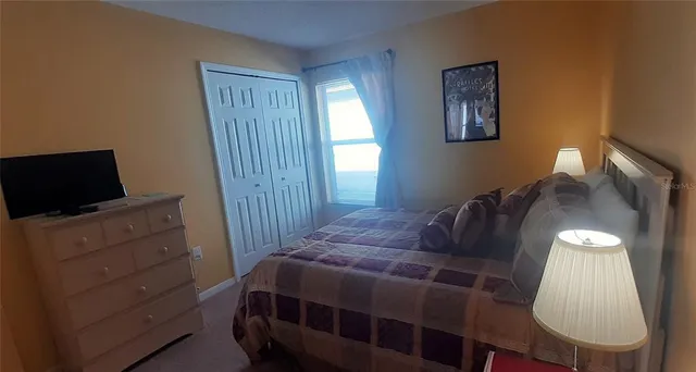 a bedroom with a bed and a mirror on the dresser