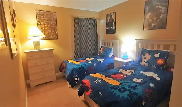 a bedroom with a bed and a lamp on dresser