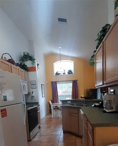 a kitchen with a refrigerator and a stove top oven