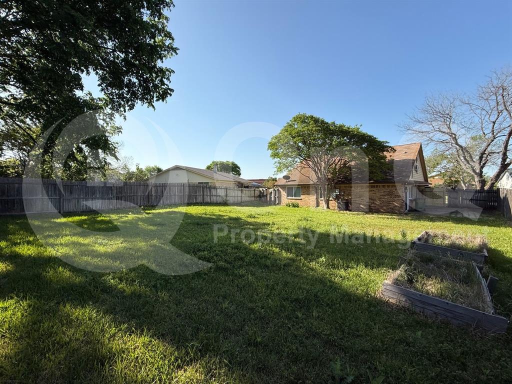 3005 Meandering Way Bedford, TX 76021 - Photo 22 of 24 Expansive backyard featuring a manicured lawn, a full wood privacy fence, and mature trees providing natural shade