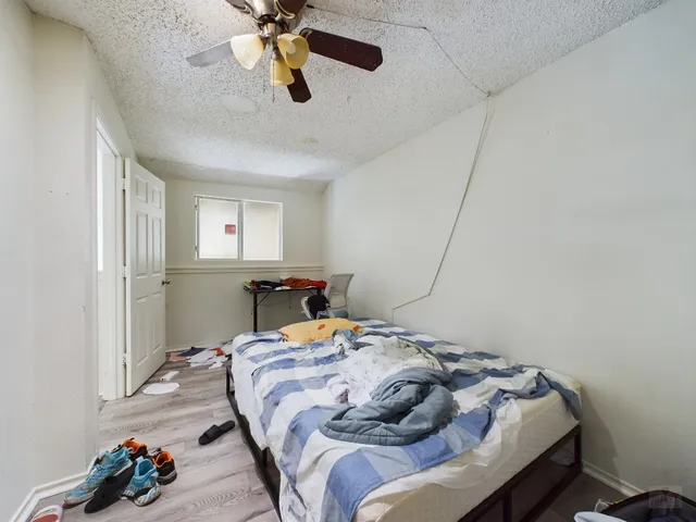 a bedroom with a bed and ceiling fan