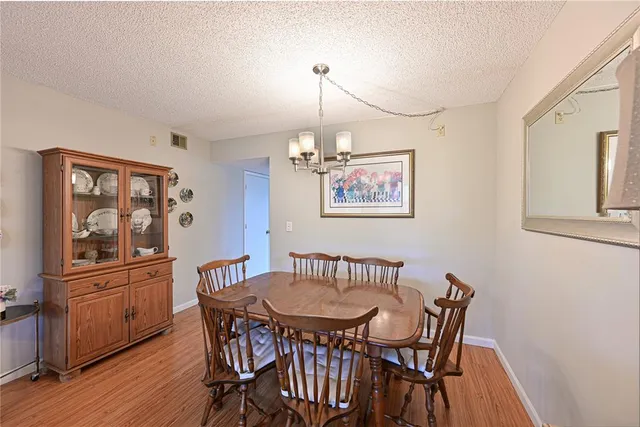 a view of a dining room with furniture a chandelier and wooden floor