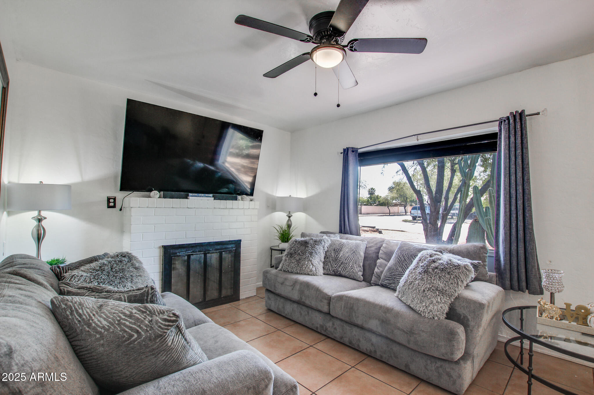 3273 East 27th Street Tucson, AZ 85713 - Photo 11 of 39 a living room with furniture a fireplace and a flat screen tv