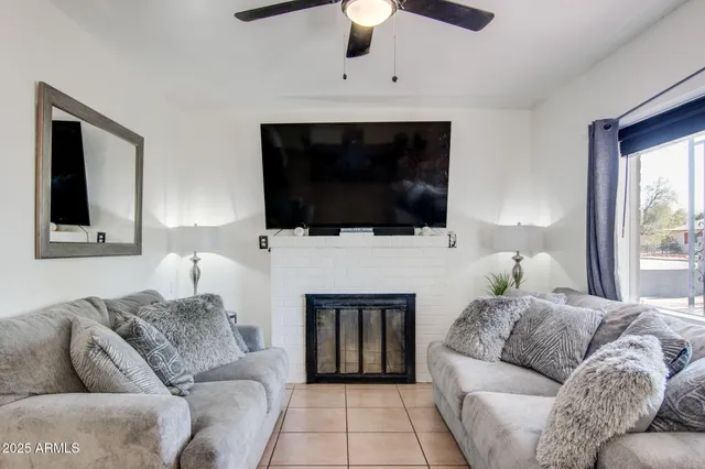 a living room with furniture a fireplace and a flat screen tv