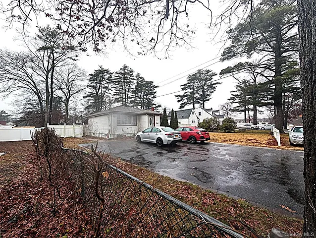 a view of a yard with car parked on the road