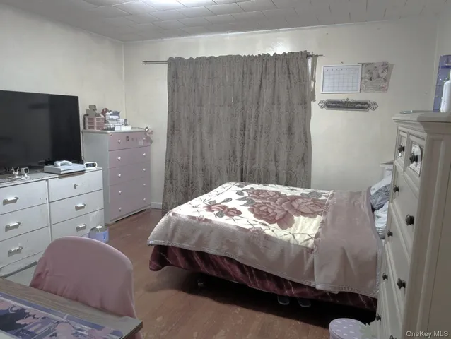a living room with furniture a flat screen tv and a floor to ceiling window