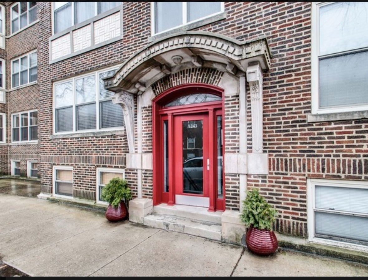 a view of a brick building with potted plants