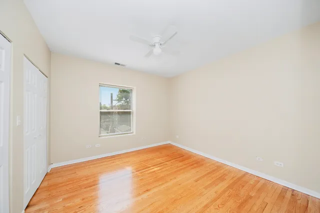 a view of a room with wooden floor and fan