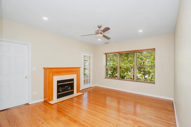 a view of empty room with wooden floor and fireplace