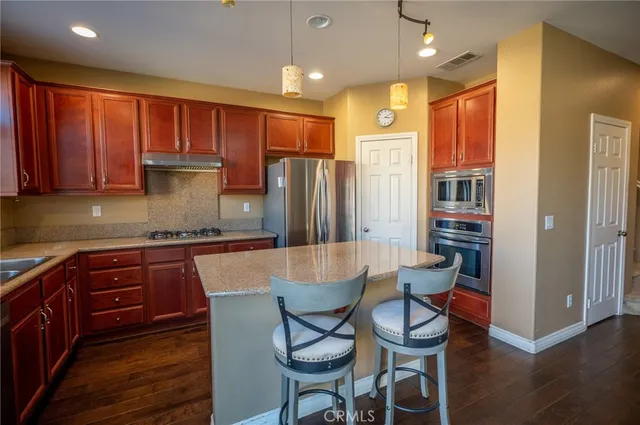 a kitchen with a table chairs refrigerator and cabinets