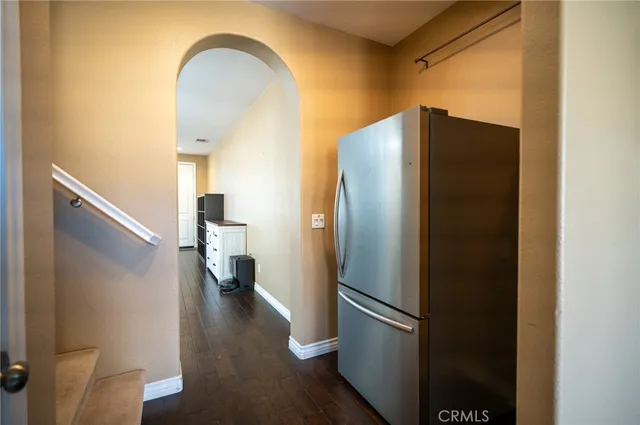 a kitchen with a refrigerator and a wooden floor