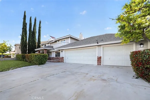 front view of a house with a small yard and a large tree