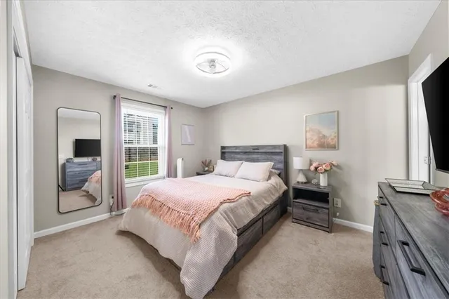 a bedroom with a bed and a large window