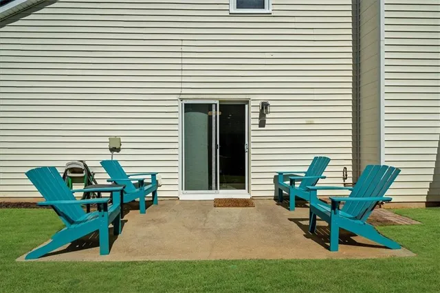 a view of a house with back yard and sitting area