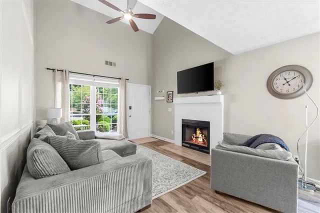a living room with furniture a flat screen tv and a fireplace