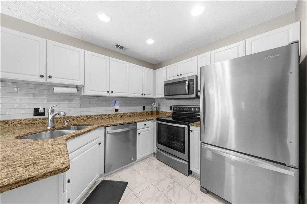 820 Camelon Court Alpharetta, GA 30004 - Photo 10 of 33 a kitchen with stainless steel appliances granite countertop a refrigerator sink and stove