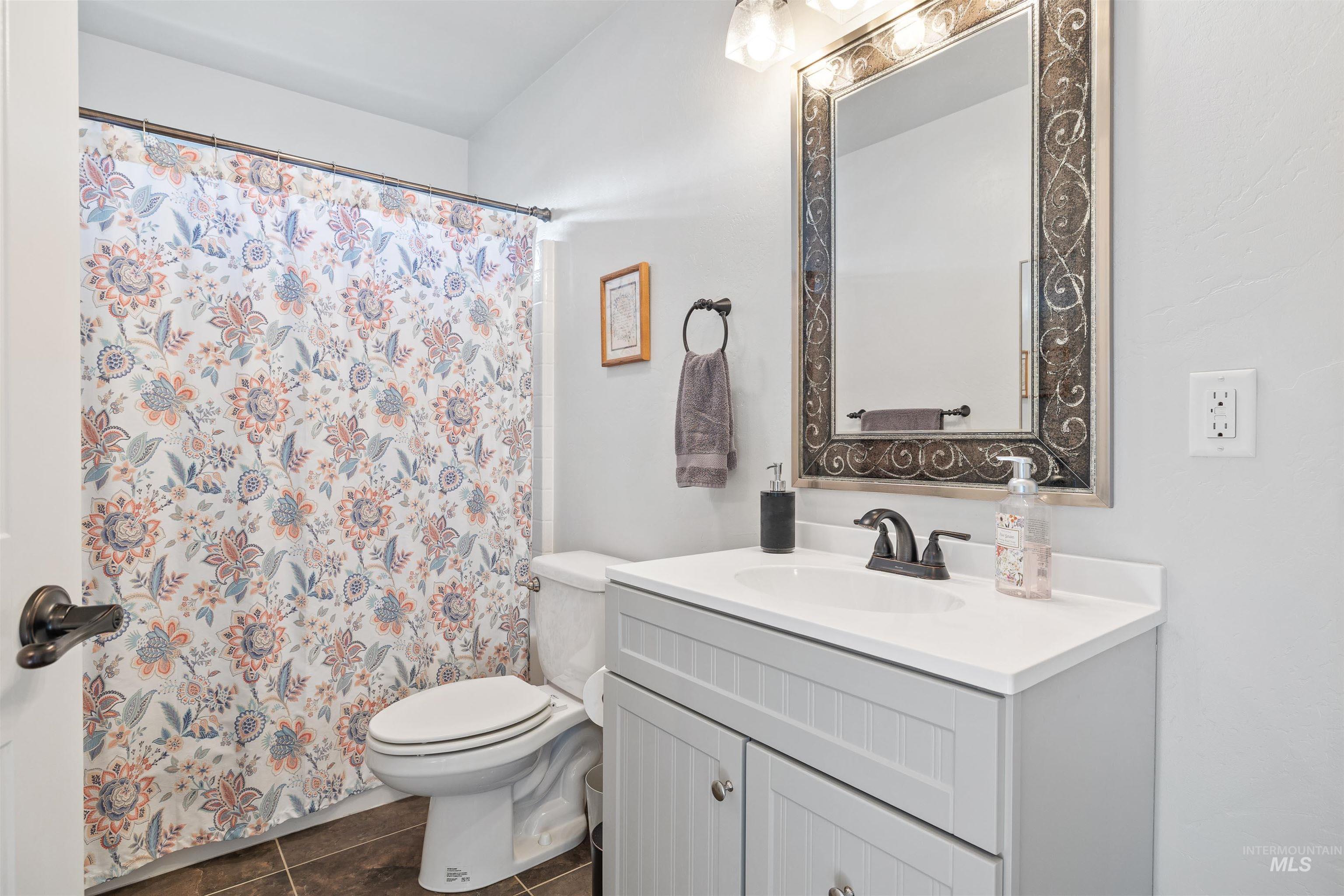 330 Arrowhead Path Twin Falls, ID 83301 - Photo 17 of 37 Full bath with vanity, curtained shower, and dark tile patterned floors
