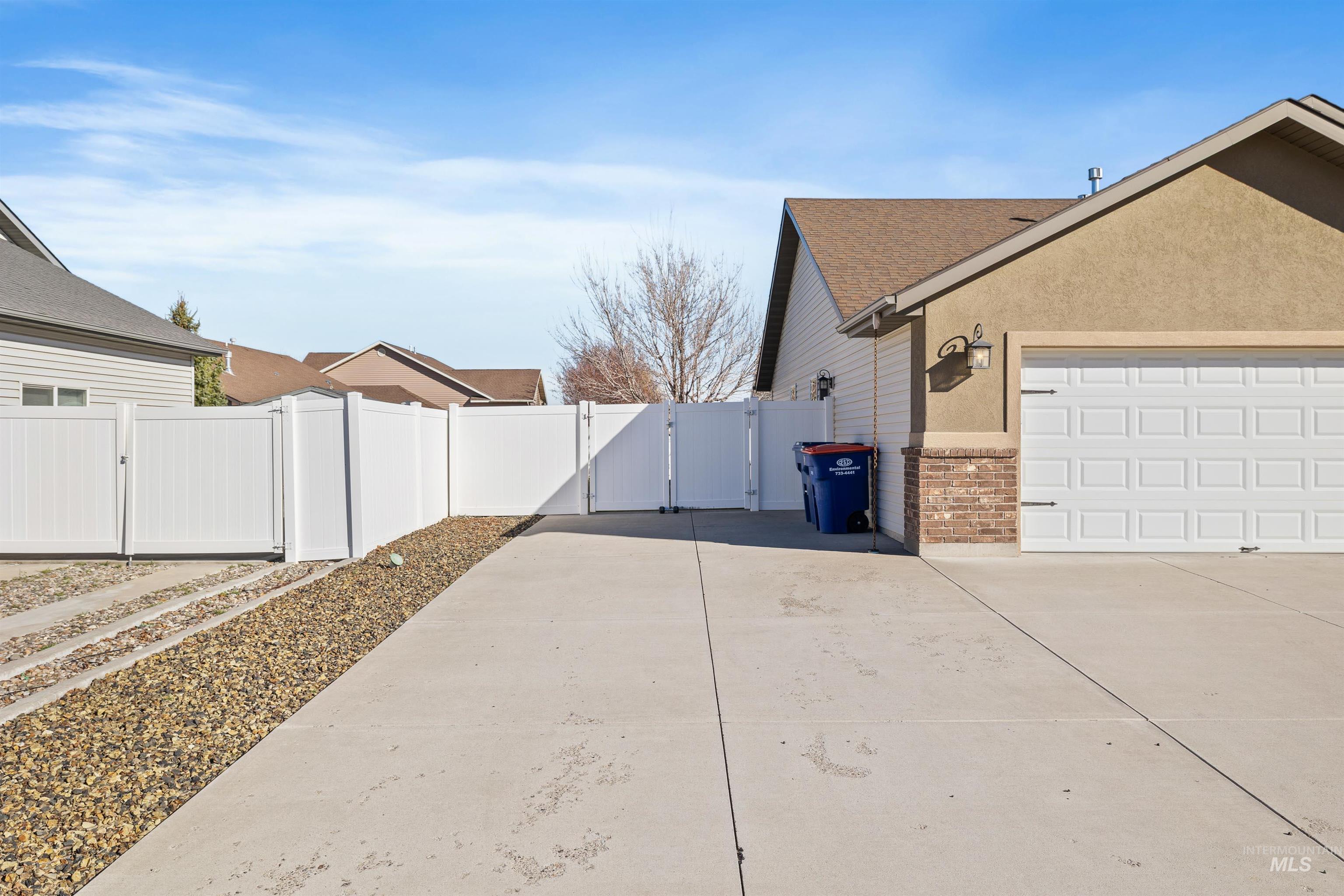 330 Arrowhead Path Twin Falls, ID 83301 - Photo 26 of 37 View of property exterior with a gate, driveway, stucco siding, and a shingled roof