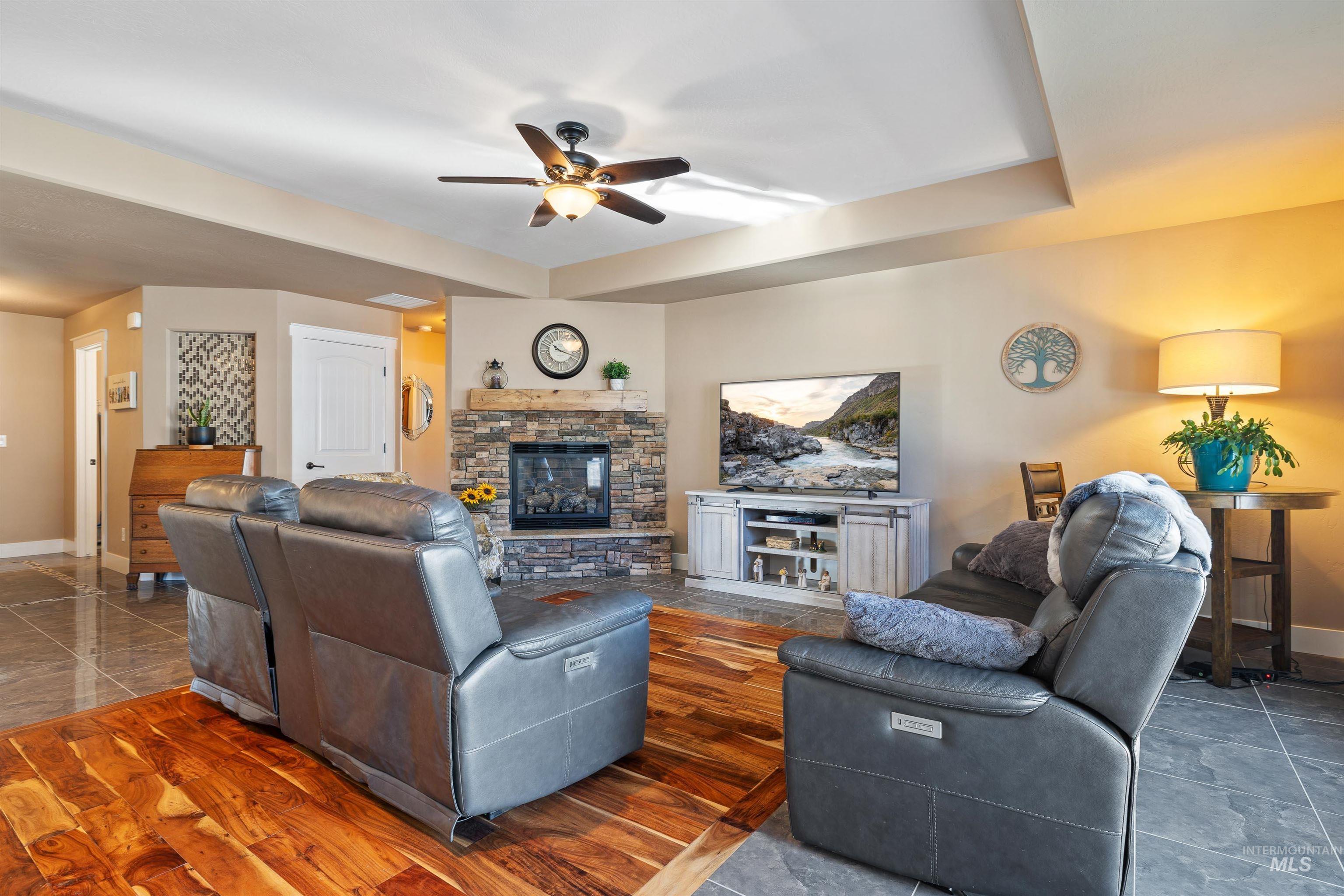 330 Arrowhead Path Twin Falls, ID 83301 - Photo 5 of 37 Living area featuring ceiling fan, a fireplace, and dark wood-style floors