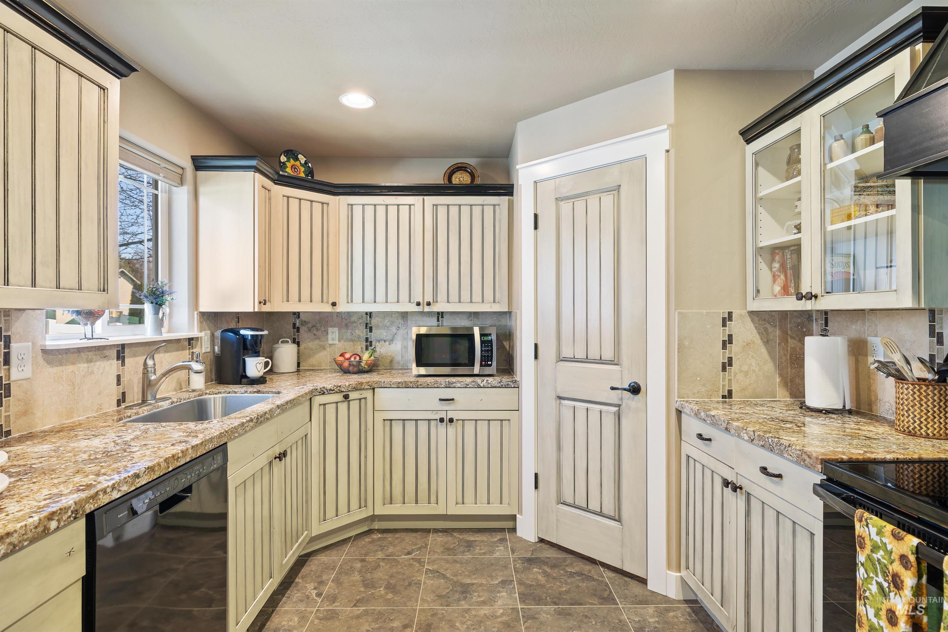 330 Arrowhead Path Twin Falls, ID 83301 - Photo 7 of 37 Kitchen with black appliances, light stone countertops, cream cabinetry, tasteful backsplash, and recessed lighting