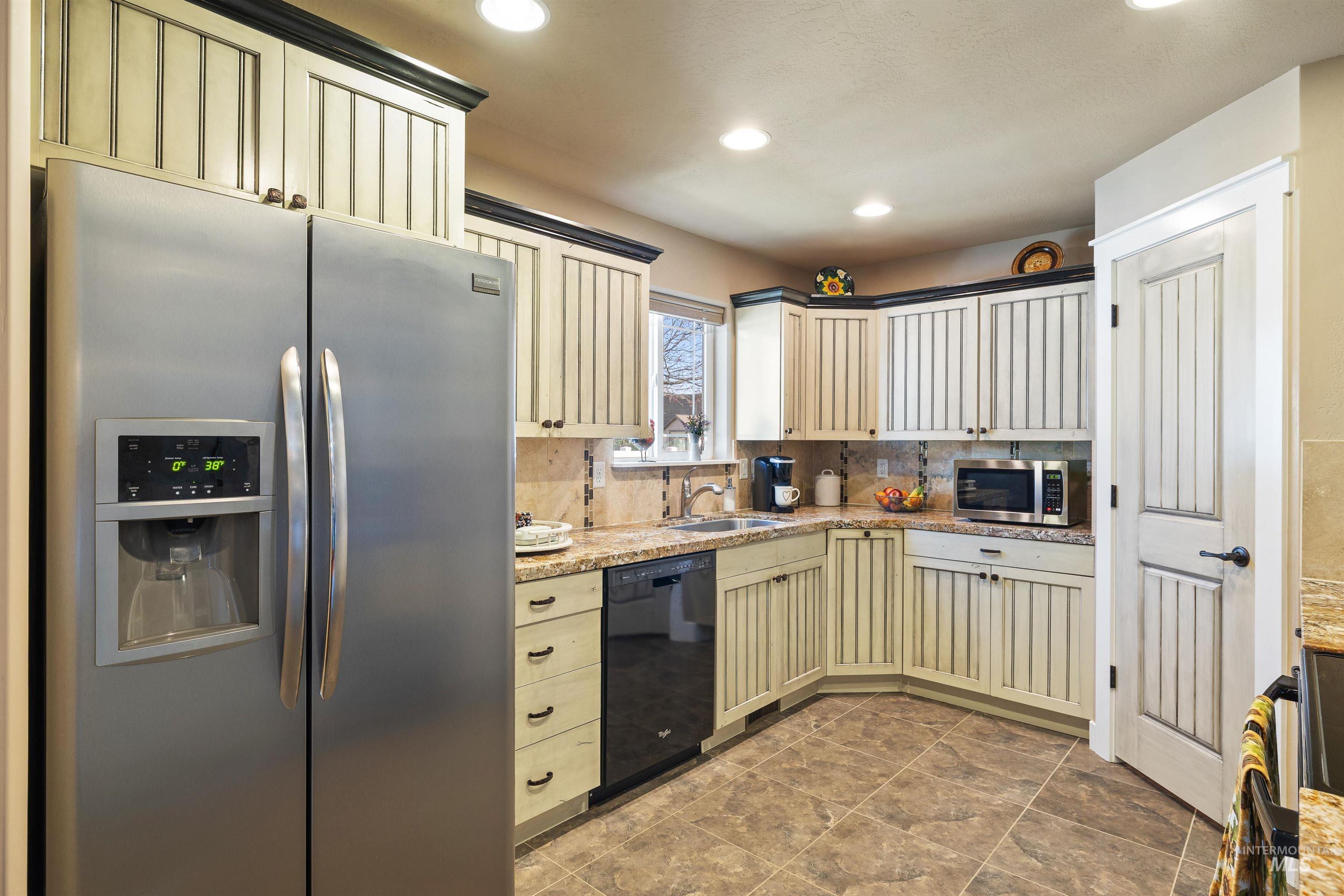 330 Arrowhead Path Twin Falls, ID 83301 - Photo 8 of 37 Kitchen with stainless steel appliances, cream cabinetry, light stone counters, decorative backsplash, and recessed lighting