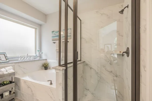 a bathroom with a white bath tub and a shower
