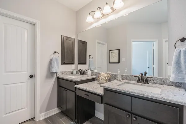a bathroom with double vanity and a mirror