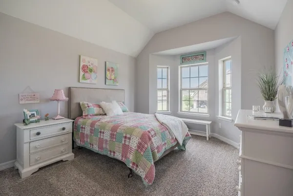 a bedroom with a bed and a potted plant on a dresser
