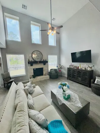 a living room with furniture a flat screen tv and a fireplace