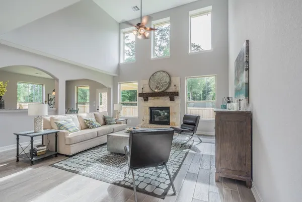 a living room with furniture a fireplace a clock and a large window