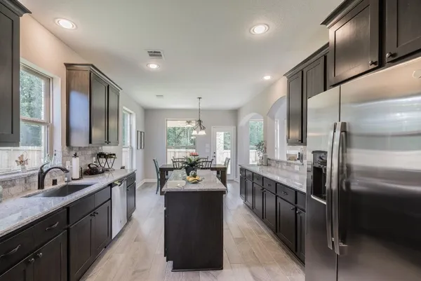 a large kitchen with kitchen island a sink stove and refrigerator